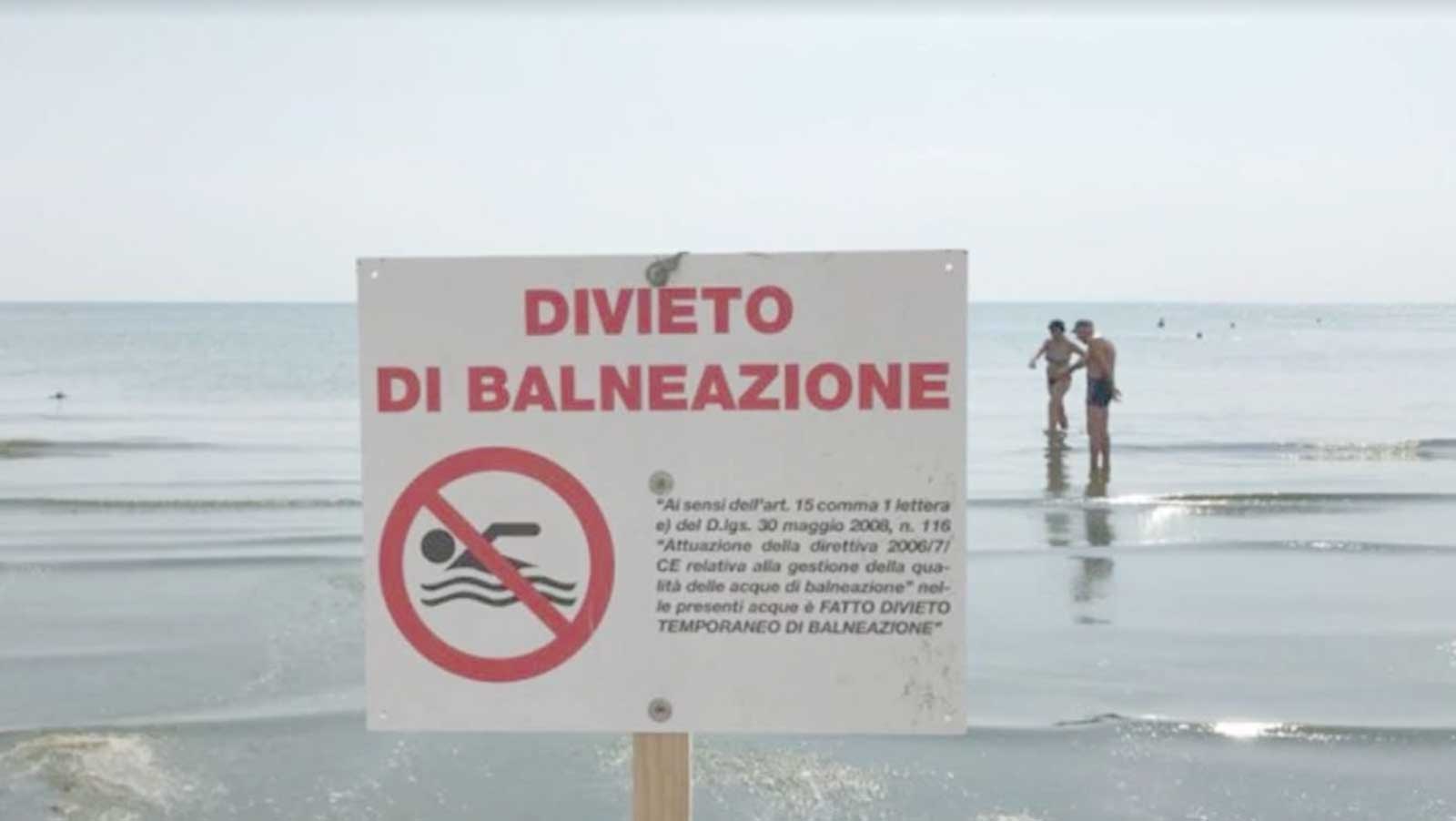 Un cartello con divieto di balneazione tra Pomezia e Ardea