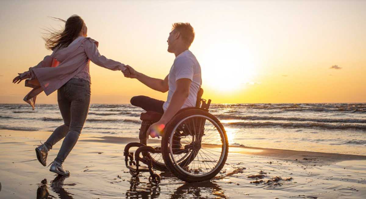 Un disabile al mare, sulla spiaggia, con carrozzina, foto generica