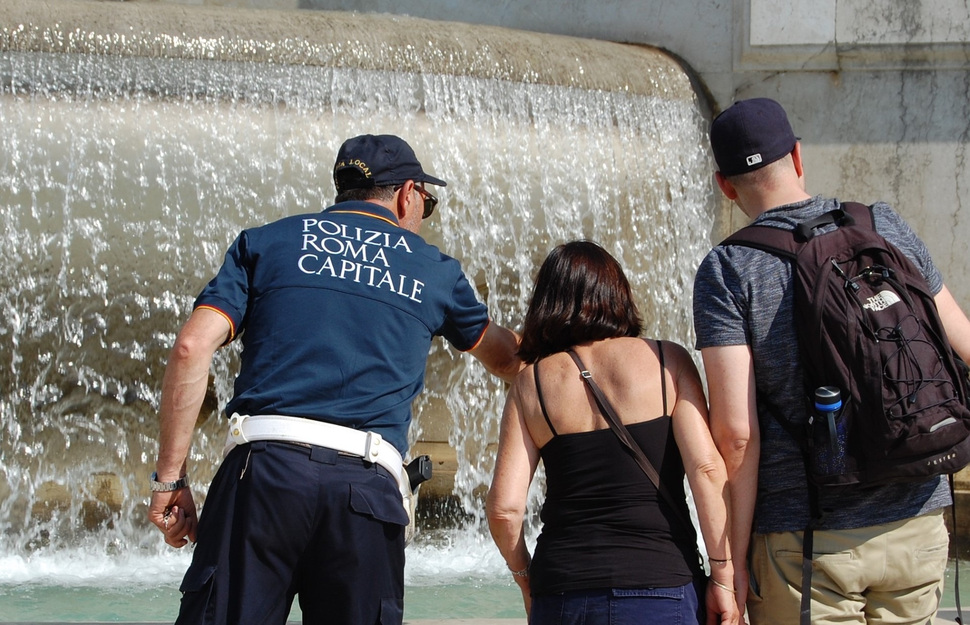 donna intenta ad immergere le gambe nella fontana di Trevi