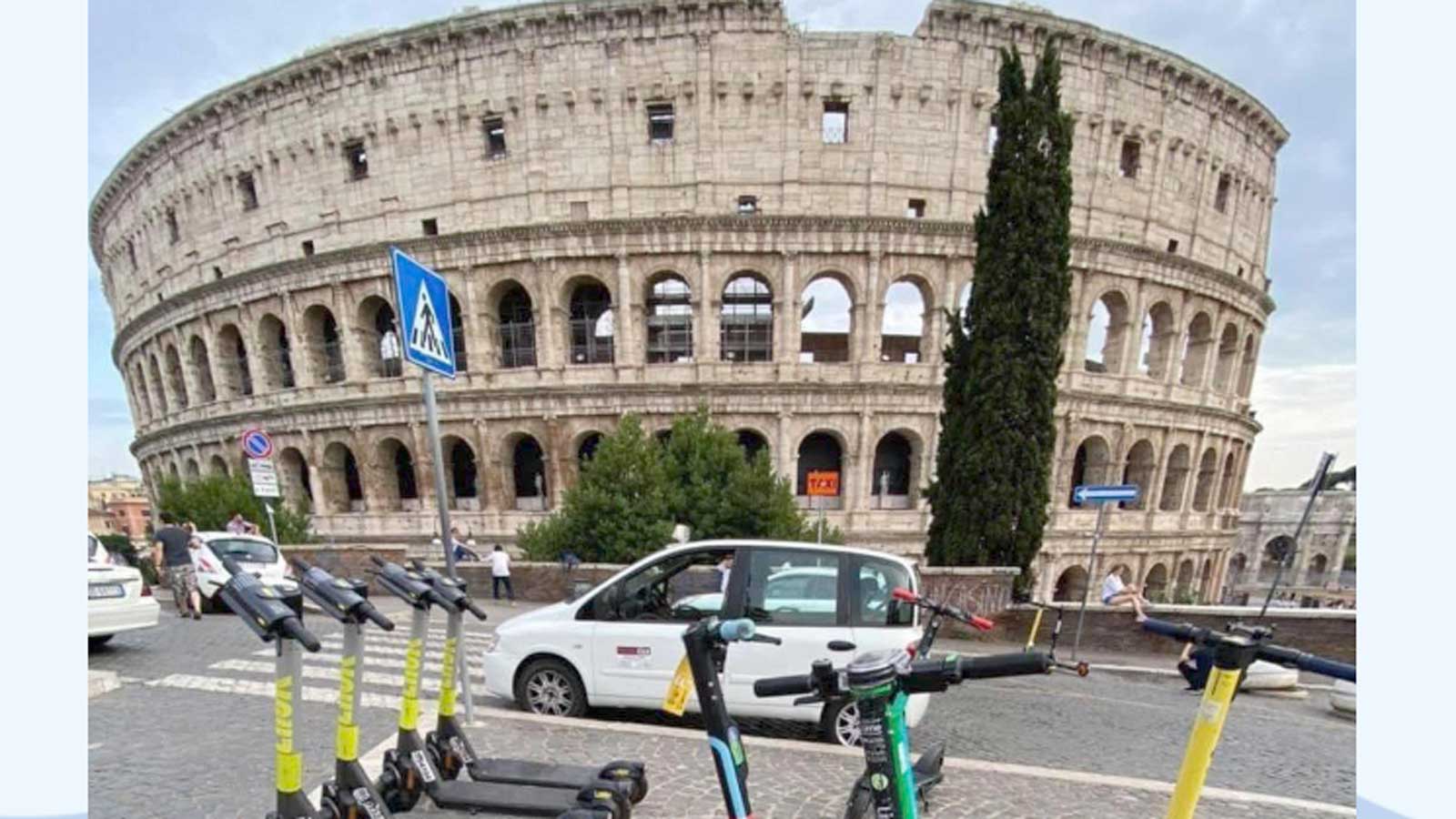 Roma, monopattini davanti al Colosseo, dietro un taxi