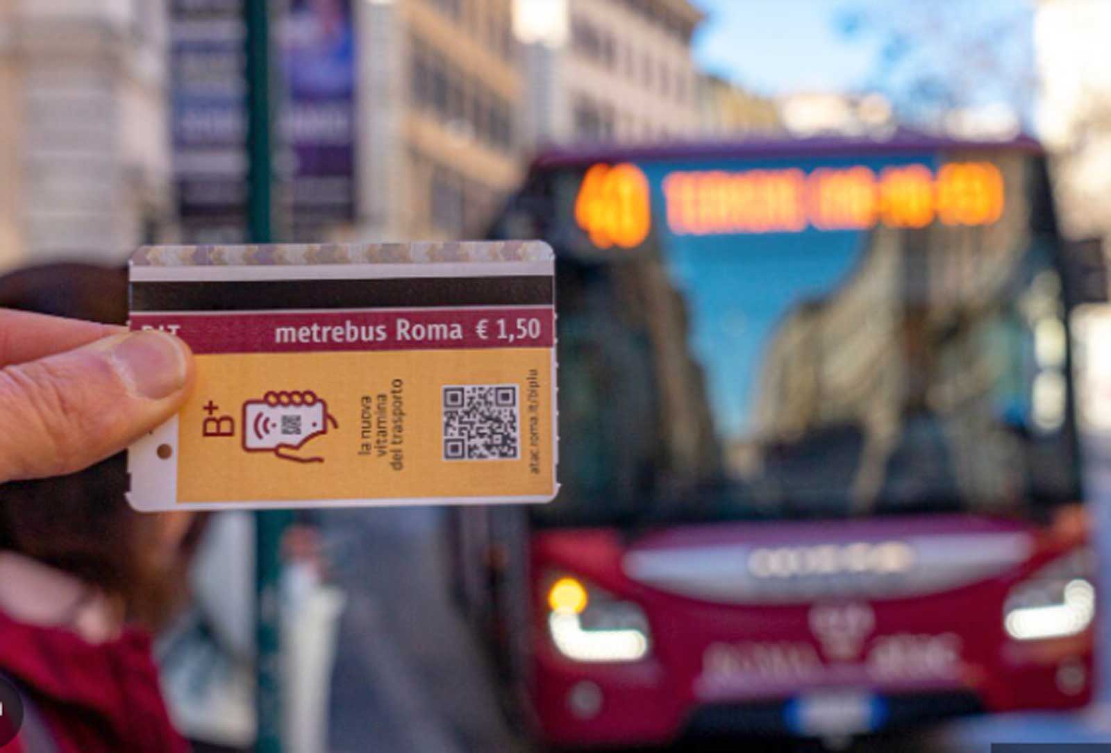 Un biglietto Atac metro e bus davanti ad un bus di Roma